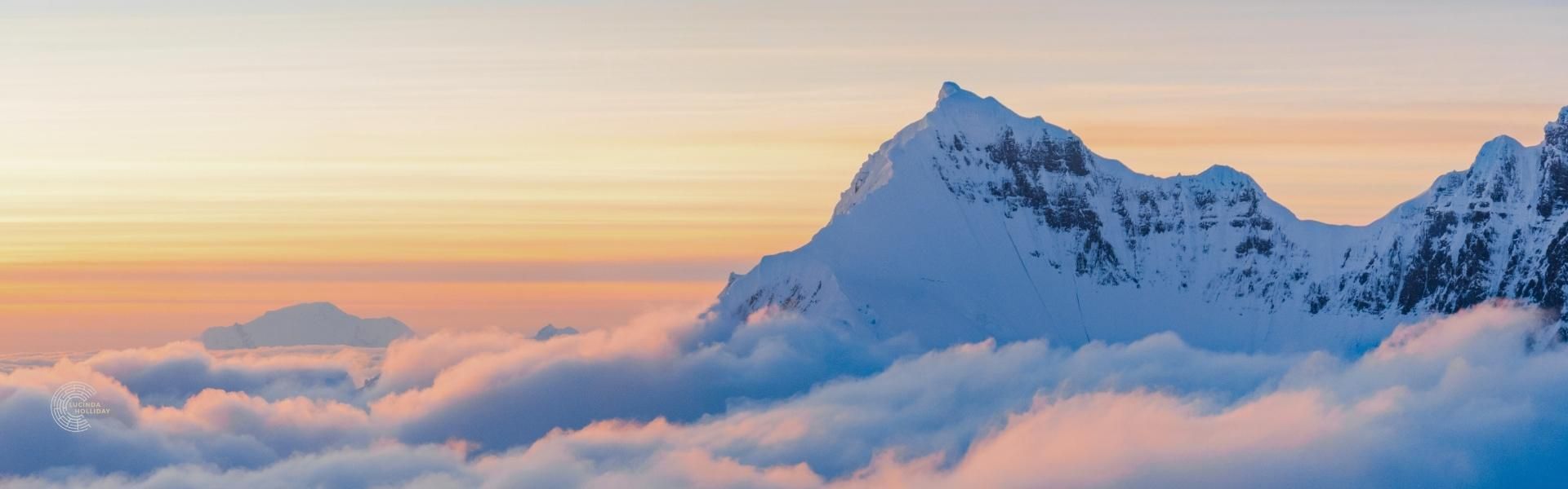 Snowy mountain above the clouds as sunrise Snowy mountain above the clouds as sunrise
