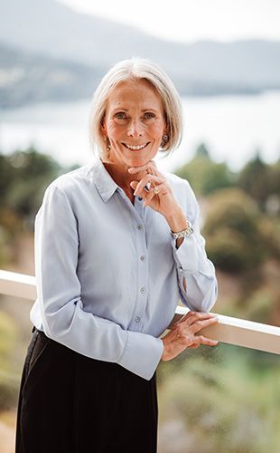 Lucinda Holliday, Separation & Divorce Consultant smiling with lake background
